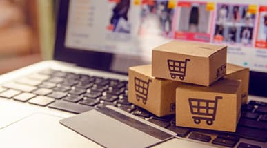 Stack of cardboard packages on top of laptop symbolizing e-commerce development stack
